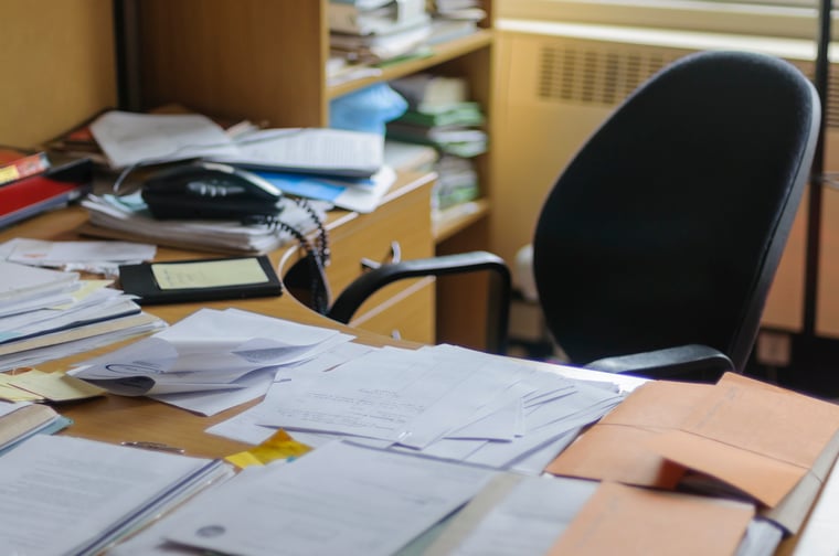 Messy desk filled with paperwork and documentation