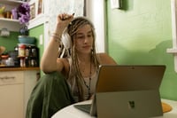 Student sitting in front of laptop in student accomodation kitchen